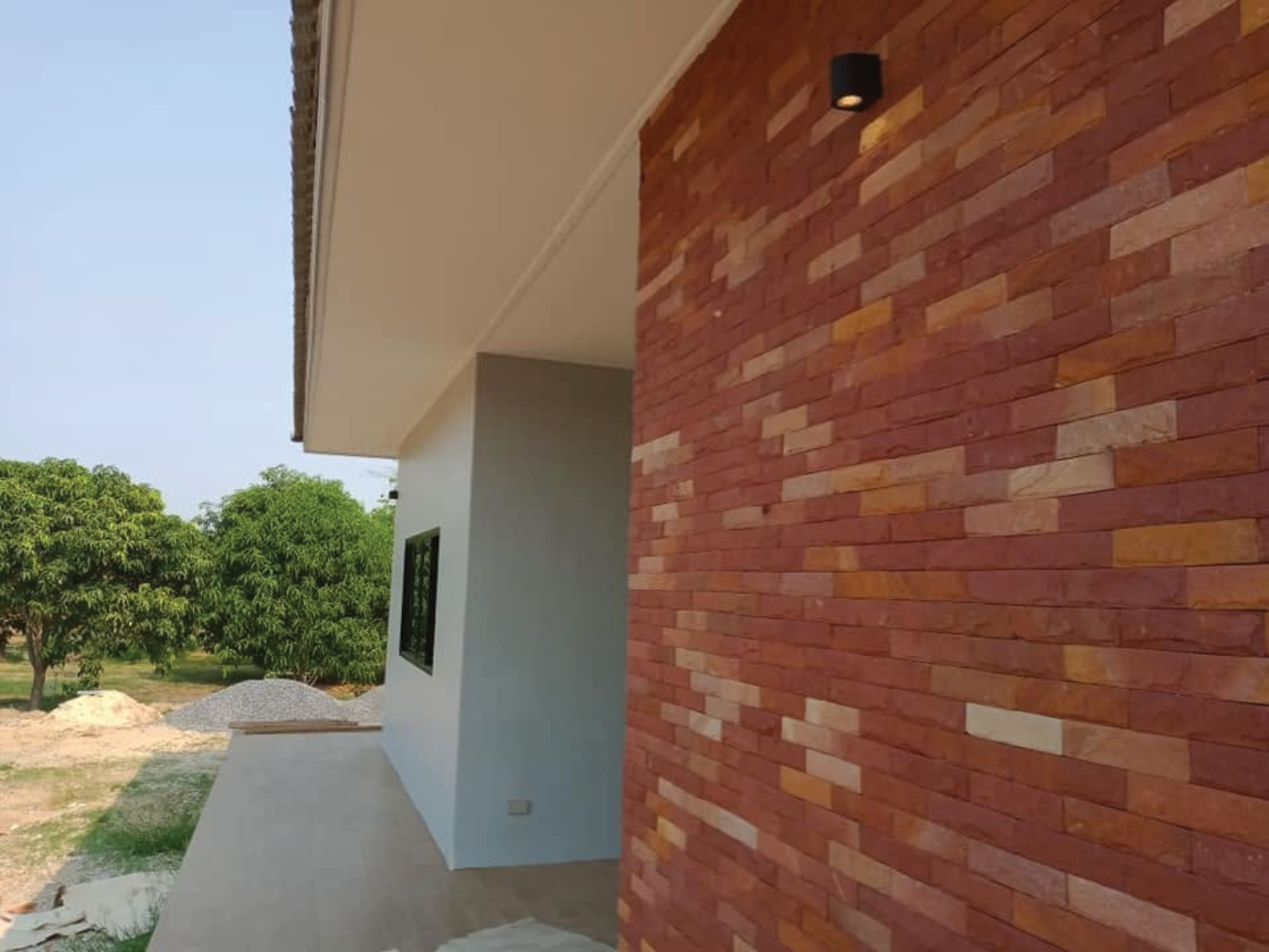 งานติดตั้งโคมไฟกิ่งตกแต่งผนังหินกาบบริเวณหลังบ้าน พร้อมจัดตำแหน่งไฟส่องสว่างให้เหมาะกับงานตกแต่งภายนอกบ้าน