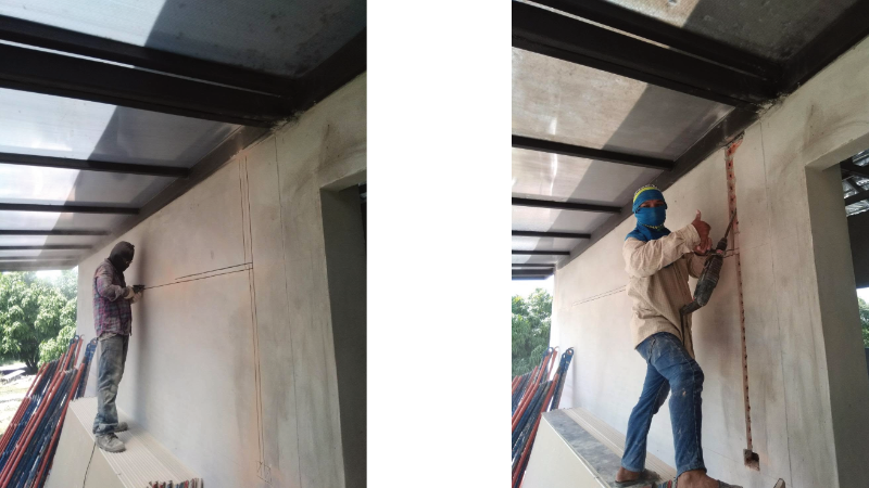 ทีมช่างไฟฟ้าร่วมกันกรีดผนังและสกัดปูนเพื่อเตรียมแนวฝังท่อร้อยสายไฟบริเวณหน้าบ้าน สำหรับงานแก้ไขระบบไฟฟ้า
