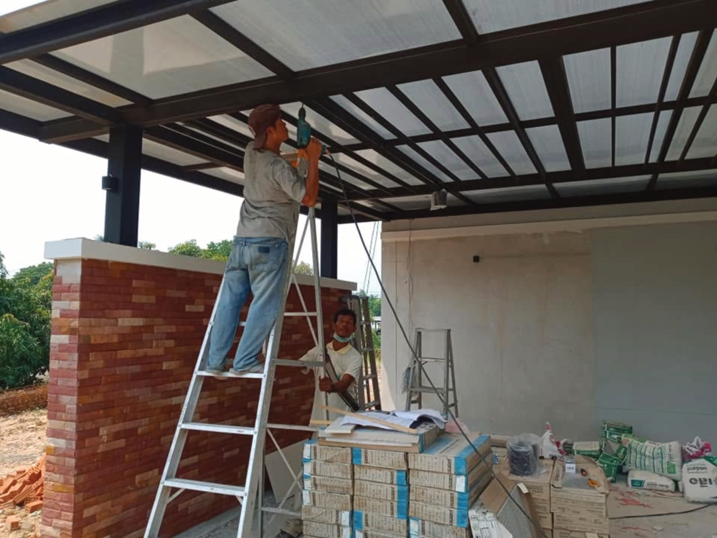 ทีมช่างไฟฟ้าร่วมกันเดินท่อร้อยสายไฟบริเวณหน้าบ้าน ในขั้นตอนแก้ไขและปรับปรุงระบบไฟฟ้าบ้านทั้งหลัง
